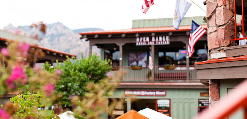 город с зелеными зданиями, флагами и видом на горы за ними